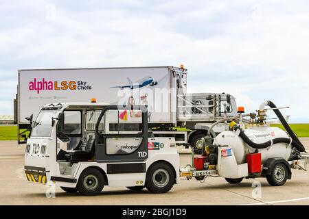 CARDIFF, WALES - JUNI 2019: Kleine Zugmaschine mit WC-Service-Tank und Ausrüstung am Flughafen Cardiff Wales. Es wird von Swissport betrieben Stockfoto