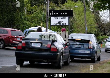 Portland, USA. April 2020. Die Menschen warten in ihren Autos auf die Lebensmittelboxen in der C3 Church Food Pantry in Portland, Oregon, am 21. April 2020. Die Speisekammer hat die Nachfrage verdreifacht als Folge des neuartigen Coronavirus, aber dank großzügiger Spenden von größeren Lebensmittelgeschäften konnten sie weiterhin einen wesentlichen Gemeinwohl bieten. (Foto: Alex Milan Tracy/Sipa USA) Quelle: SIPA USA/Alamy Live News Stockfoto