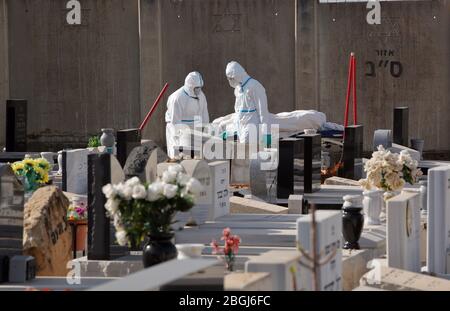 (200421) -- REHOVOT (ISRAEL), 21. April 2020 (Xinhua) -- Bestattungsarbeiter, die Masken und Schutzausrüstung tragen, tragen die Leiche eines Patienten, der am 21. April 2020 an COVID-19 gestorben ist, auf einem Friedhof in der zentralisraelischen Stadt Rehovot. Das israelische Gesundheitsministerium meldete am Dienstag 229 neue Fälle, was die Gesamtzahl der Infektionen auf 13,942 brachte. (Foto von Gil Cohen Magen/Xinhua) Quelle: Xinhua/Alamy Live News Stockfoto