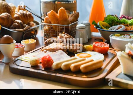 Holzbrett mit Fleisch, Würstchen zum Frühstück Stockfoto