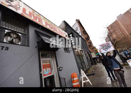 New York City, USA. April 2020. Zwei PETA-Anhänger halten Protestschilder vor La Granja Live Poultry, einem Markt für lebende Tiere, der auch als „Feuchtmarkt“ bezeichnet wird, im Harlem-Teil von New York City, NY, 21. April 2020. Tierrechtsgruppen fordern die Schließung aller Feuchtmärkte, weil sie glauben, dass sie Hunde für Krankheiten züchten, wie das neuartige Coronavirus (COVID-19), das von einem Feuchtmarkt in Wuhan, China, berichtet wurde. (Anthony Behar/Sipa USA) Credit: SIPA USA/Alamy Live News Stockfoto