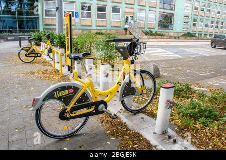 BRATISLAVA (SLOWAKEI) – OKTOBER 06 2019: Gelbes öffentliches Fahrrad in der Andockstation in der Nähe des Parkplatzes gesperrt Stockfoto