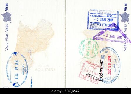 Briefmarken von Kanada, USA, Thailand und den Philippinen in einem französischen Pass Stockfoto