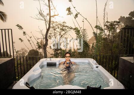 Frau, die ein Bad in einem Whirlpool im Hochland von Sri Lanka genießt Stockfoto