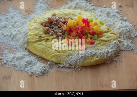 Hefeteig mit Rosinen und kandierten Früchten. Gelber Hefeteig mit kandierten Früchten und Rosinen, das Konzept des festlichen Backens. Sweet Raisin Macht Es Stockfoto