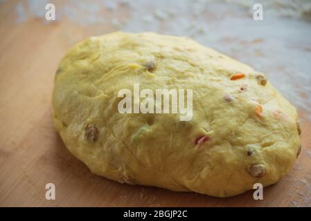 Hefeteig mit Rosinen und kandierten Früchten. Gelber Hefeteig mit kandierten Früchten und Rosinen, das Konzept des festlichen Backens. Sweet Raisin Macht Es Stockfoto