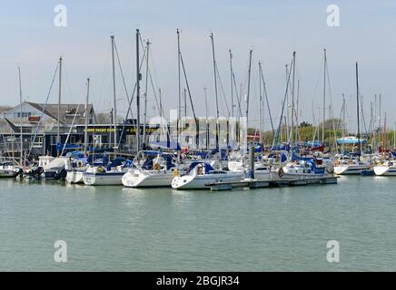 Viele Yachten der Arun Yacht Club Mitglieder haben auf dem Fluss Arun in Littlehamption, West Sussex, Großbritannien, mit dem Clubgebäude hinter sich gefestt. Stockfoto