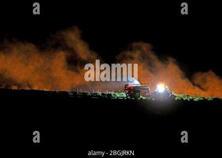 Ballycastle, Nordirland. April 2020. Bauern sprühen Wasser, während ein Wildfeuer weiterhin wütete, um das Dorf Armoy in der Grafschaft Antrim zu erreichen, mehr als 70 Feuerwehrleute waren heute am Ort, eine Reihe von Bauernhäusern sind in der Nähe des Feuers. PIC Steven McAuley/McAuley Multimedia Credit: Steven McAuley/Alamy Live News Stockfoto