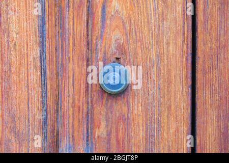 Ein Guckloch in der lackierten Holztür. Stockfoto