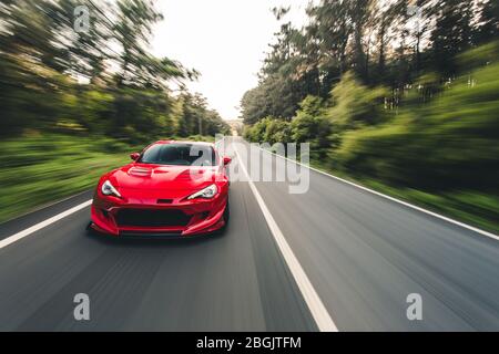 Superpower roten Rennwagen auf der Landschaft fahren Stockfoto