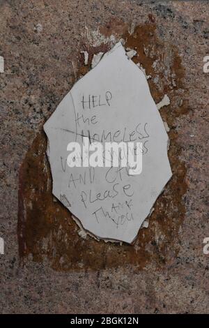 'HILF den Obdachlosen mit Freundlichkeit und Fürsorge, bitte.Danke'- eine kleine Nachricht geschrieben auf einem gebrochenen Stück Fliese, die an eine Wand in Glasgow, Schottland, geklebt ist. Stockfoto