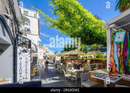 Ein kleines Café am Meer und Geschäfte unter einem Efeu Baldachin an der Amalfi Küste in der Stadt Amalfi, Italien. Stockfoto