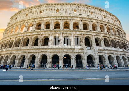 Touristen versammelt sich vor der berühmten Kolosseum in Rom, Italien, wie die Sonne untergeht, in der historischen, alten Stadt. Stockfoto