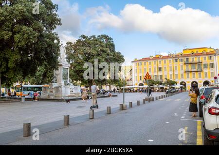 Lokale Französisch Genießen Sie einen späten Nachmittag auf dem Place Garibaldi, während ein Tourist ein Foto vom Brunnen in Nizza, Frankreich, macht. Stockfoto