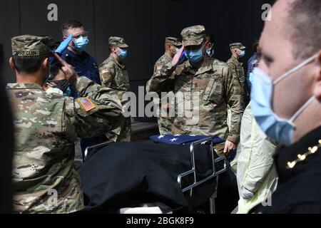 New York Army National Guard Sgt. Major Nicholas Pardi, Mitglied des 104. Militärpolizeibataillons, überreicht während einer Gedenkfeier für einen Veteranen, der an COVID 19 starb, während ein Patient auf der Javits New York Medical Station im Jacob Javits Convention Center in New York City, Am 19. April 2020. Aktive Militärs und Mitglieder der New York National Guard Military, zusammen mit Mitarbeitern, die vor dem Militärdienst stehen, erbrachten letzte Ehren, als seine Überreste übertragen wurden (Foto der U.S. Air National Guard von Major Patrick Cordova) Stockfoto