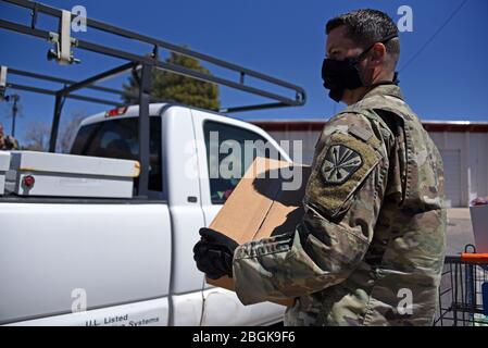 Mitarbeiter der Arizona National Guard liefern Kisten mit frischen Produkten und Lebensmitteln an Bewohner von Coconino County, Arizona, 7. April 2020 im Flagstaff Family Food Center. Mehr als 800 AZNG-Mitarbeiter sind nach wie vor im gesamten Staat als Reaktion auf den laufenden Notfall tätig. (USA Foto der Air National Guard von Stabsfeldwebel Kelly Greenwell) Stockfoto