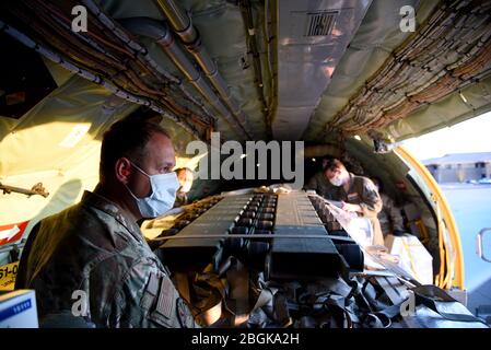 161st Air Tanken Wing Service-Mitglieder entladen Material von einem KC-135 Stratotanker verwendet werden, um Schutzkleidung für den landesweiten Einsatz zu machen April 9, 2020 auf Goldwater Air National Guard Base, Phoenix. Die Lieferung ist Teil der Arizona National Guard Antwort auf die Bedürfnisse der Gemeinschaft während dieses Ausnahmezustands (USA Air National Guard Foto von Tech. Sgt. Michael Matkin). Stockfoto