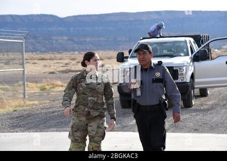 LT. Maram Sweis, Arizona Army National Guard Medical Operations Officer, Und Benny Fate, Leiter der Sicherheitsdienste des Kayenta Krankenhauses, diskutiert die Entladung von medizinisch-persönlichen Schutzausrüstung aus einem UH-60 Blackhawk 31. März 2020 in Kayenta, Arizona. Die Arizona Guard hat im Inland in solchen Notfällen reagiert, wie die Flughafensicherheit nach dem 11. September, das Monument Fire 2011, der Hurrikan Harvey 2017, Und die Havasupai Überschwemmungen im Jahr 2018 (USA Air National Guard Foto von Tech. Sgt. Michael Matkin). Stockfoto