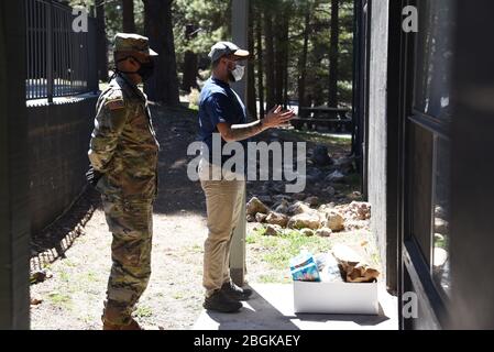 Mitarbeiter der Arizona National Guard liefern Kisten mit frischen Produkten und Lebensmitteln an Bewohner von Coconino County, Arizona, 7. April 2020 im Flagstaff Family Food Center. Mehr als 800 AZNG-Mitarbeiter sind nach wie vor im gesamten Staat als Reaktion auf den laufenden Notfall tätig. (USA Foto der Air National Guard von Stabsfeldwebel Kelly Greenwell) Stockfoto