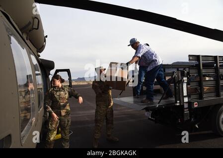 2. LT. Maram Sweis, Arizona Army National Guard Medical Operations Officer und Sgt. Jonathan Atcitty, der Crew-Chef der Arizona Army National Guard, und das Personal des Kayenta Krankenhauses, verladen medizinische persönliche Schutzausrüstung von einem UH-60 Blackhawk in einen Lastwagen am 31. März 2020 in Kayenta, Arizona. Die Arizona National Guard flog medizinische PSA zum örtlichen Krankenhaus als Reaktion auf COVID-19. Die Arizona Guard hat im Inland in solchen Notfällen wie Flughafen Sicherheit nach 11 9/9, Monument Fire in 2011, Hurrikan Harvey in 2017 und die Havasupai Überschwemmungen in 2018 (USA Air National Guard Foto von Tech. Sg Stockfoto