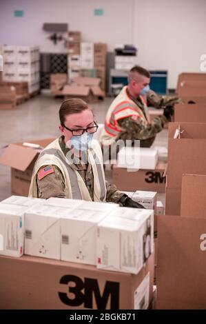 Soldaten der Oregon Army National Guard bereiten Sendungen von kritischer persönlicher Schutzausrüstung (PSA) in einem Lager des Oregon Department of Administrative Services (das) vor, 17. April 2020. Diese Notlieferungen werden von der Oregon Guard an Einrichtungen für betreutes Wohnen im ganzen Staat geliefert, die unter schweren Mangel an PSA leiden. (FOTO der US Army National Guard von Sgt. 1. Klasse Zachary Holden, Oregon Military Department) Stockfoto