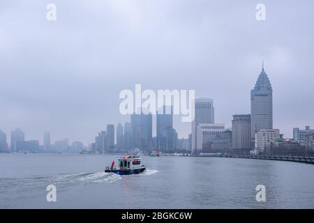 Ein Schiff bewegt sich auf dem Huangpu Fluss mit lokalen Sehenswürdigkeiten wie Shanghai World Financial Center, Oriental Pearl Tower, Jin Mao Tower und Shanghai Tow Stockfoto