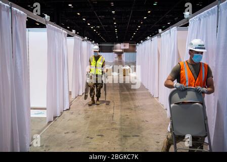 Mitglieder der Illinois Air National Guard montieren Ausrüstung im McCormick Place Convention Center als Reaktion auf die COVID-19-Pandemie in Chicago, Abb., 8. April 2020. Etwa 60 Mitglieder der Illinois Air National Guard wurden aktiviert, um das US Army Corps of Engineers und die Federal Emergency Management Agency (FEMA) zu unterstützen, um einen Teil des McCormick Place Convention Centers vorübergehend in eine Alternate Care Facility (ACF) für COVID-19-Patienten mit leichten Symptomen umzuwandeln Keine Intensivpflege in der Gegend von Chicago erforderlich. (USA Air Force Foto von Senior Airman Jay Grabiec) Stockfoto