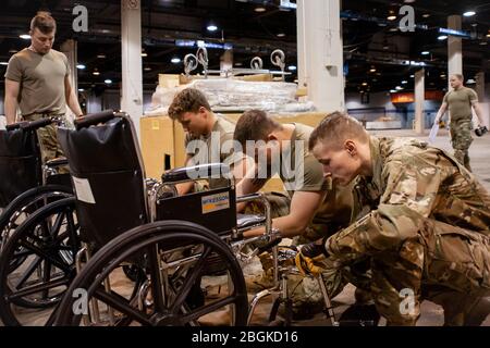 Mitglieder der Illinois Air National Guard stellen medizinische Geräte im McCormick Place Convention Center zusammen, als Reaktion auf die COVID-19-Pandemie in Chicago, Illinois, 30. März 2020. Etwa 30 Mitglieder der Illinois Air National Guard wurden aktiviert, um das US Army Corps of Engineers und die Federal Emergency Management Agency (FEMA) zu unterstützen, um einen Teil des McCormick Place Convention Center vorübergehend in eine Alternate Care Facility (ACF) für COVID-19-Patienten mit leichten Symptomen umzuwandeln Keine Intensivpflege im Gebiet von Chicago erforderlich. (USA Air Force Foto von Senior Airman Jay Grab Stockfoto