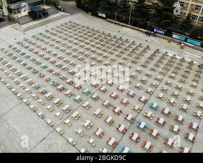 Eine Luftaufnahme von über 300 Tischen und 1200 Stühlen wird außerhalb der Tür bewegt und auf einem Öffnungsbereich der Hunan University of Technology, Zhengzhou CI gestellt Stockfoto