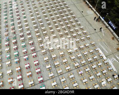 Eine Luftaufnahme von über 300 Tischen und 1200 Stühlen wird außerhalb der Tür bewegt und auf einem Öffnungsbereich der Hunan University of Technology, Zhengzhou CI gestellt Stockfoto