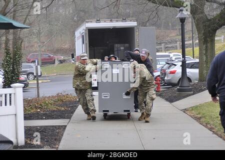 New York Army National Guard Pfc. Edson Olivares, links, zugewiesen an die 719. Transportation Company, und Pvt. Daniel Sgobbo, der 1156. Ingenieurgesellschaft, die beide Teil des 53. Truppenkommandos sind, ist bei der Platzierung von Zelten im New York-Presbyterian-Hudson Valley Hospital in Cortlandt Manor, New York, behilflich, da medizinische Einrichtungen sich auf die Reaktion auf den Ausbruch von COVID 19 Patienten am 20. März 2020 vorbereiten. Die Soldaten sind Teil der landesweiten Bemühungen, Mitglieder der Nationalgarde zur Unterstützung der lokalen Behörden während der Pandemie einzusetzen. Foto der US Army National Guard von Col. Ric Stockfoto