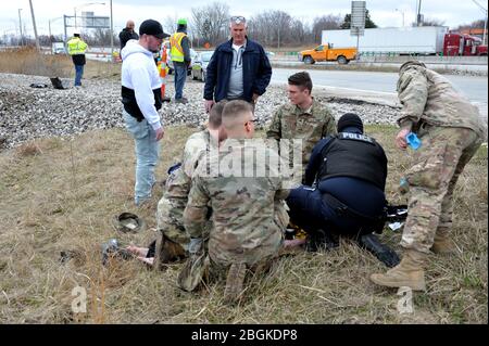 Soldaten der US Army National Guard, die dem HHC 1-148. Infanterie-Regiment der Ohio National Guard – 37. Infanterie-Brigade Combat Team zugewiesen wurden, unterstützen nach einem einzigen Fahrzeugunfall in der Nähe von Toledo, Ohio, 23. März 2020. Soldaten der Nationalgarde und Luftwaffe nehmen regelmäßig an umfangreichen Selbsthilfe- und Pflegeschulungen Teil, um ihnen die notwendigen Fähigkeiten zur Erhaltung von Leben, Gliedmaßen und Sehvermögen zu vermitteln; um eine Verschlechterung der Situation zu vermeiden und die Opfer zu weiterer medizinischer Hilfe zu bewegen; Und den Mitgliedern die Möglichkeit zu geben, sich selbst oder andere bei Bedarf zu versorgen, im Kampf und hier zu Hause. Air Nati Stockfoto