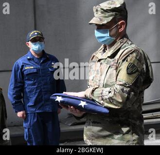New York Army National Guard Sgt. Major Nicholas Pardi, Mitglied des 104. Militärpolizeibataillons, überreicht während einer Gedenkfeier für einen Veteranen, der an COVID 19 starb, während ein Patient auf der Javits New York Medical Station im Jacob Javits Convention Center in New York City, Am 19. April 2020. Aktive Militärs und Mitglieder der New York National Guard Military, zusammen mit Mitarbeitern, die vor dem Militärdienst stehen, erbrachten letzte Ehren, als seine Überreste übertragen wurden (Foto der U.S. Air National Guard von Major Patrick Cordova) Stockfoto