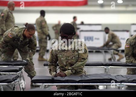 Armee-Pfc. Ndeye Diongue, die dem 1297. Unterstützungsbataillon der Maryland Army National Guard zugewiesen wurde, stellt ein Kinderbett und Bettwäsche zusammen, während sie und andere Soldaten am Samstag, den 28. März 2020, eine Federal Medical Station im Baltimore Convention Center in Baltimore, Maryland, einrichten. Die Station wurde als alternatives medizinisches Zentrum konzipiert und sollte eine mögliche Überbelegung von Krankenhäusern in der Umgebung infolge des Ausbruchs von COVID-19 verhindern. Rund 100 Soldaten halfen beim Aufbau von 250 Betten und damit zusammenhängender Ausrüstung im Kongresszentrum, während landesweit fast 14,000 Nationalgardisten Mitglieder A Stockfoto