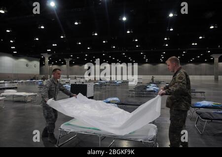 LOS ANGELES, Kalifornien - Airmen 1st Class Clark Girbovan, 146 Airlift Wing Water and Fuel Systems Maintenance Apprentice und Senior Airman Erik Shaw, 146 AW Fuels Journeyman helfen, Betten für einen Quarantänebereich im LA Convention Center für COVID-19-Patienten am 29. März 2020 einzurichten. Insgesamt 250 Betten wurden im 720.000 Quadratmeter großen Kongresszentrum eingerichtet. (USA Armeefotos des Personals Sgt. Katie Grandori, 79th Infantry Brigade Combat Team) Stockfoto