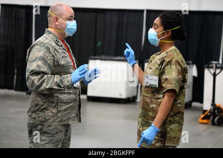 Von links: US Air Force Capt. Kerwin K. Barden Jr., der stellvertretende Direktor der Krankenpflege bei der Meadowlands Task Force, Und Maj. Lauren W. Carter, Assistentin des Arztes beim 177. Jagdflügel, besprechen die Logistik medizinischer Operationen am 10. April 2020 im Meadowlands Exposition Center Federal Medical Station in Secaucus, N.J. New Jersey National Guardsmen arbeitete eng mit dem Gesundheitsministerium zusammen, um das Meadowlands Exposition Center als Federal Medical Station einzurichten und zu betreiben, um die Hilfsmaßnahmen COVID-19 zu unterstützen. (USA Foto der Air National Guard von Staff Sgt. Cristina J. Allen) Stockfoto