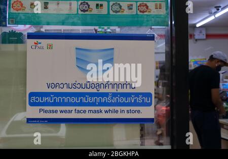 Bangkok Thailand- 18. April 2020: Nahaufnahme Warnschild lesen Bitte tragen Sie Gesichtsmaske, während im Geschäft, Sicherheitskonzept aufgrund Coronavirus Pandemie Stockfoto