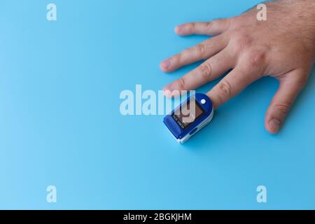 Pulsoximeter an einem männlichen Finger. Mann, der Oximeter verwendet. Gesundes Konzept Stockfoto