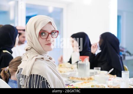 Junge muslimische Frau mit Iftar Abendessen mit Familie essen traditionelle Lebensmittel während Ramadan Festmonat zu Hause. Das islamische Halal Essen und Drinkin Stockfoto