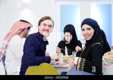 Junge muslimische Paar mit Iftar Abendessen mit Familie essen traditionelle Speisen während Ramadan Festmonat zu Hause. Das islamische Halal Essen und Drinki Stockfoto