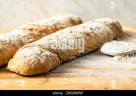 Frisches Vollkornbrot Baguette auf Holztisch. Stockfoto