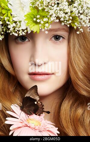 Nahaufnahme Porträt von schönen gesunden Rotschopf Teenager-Mädchen mit Schmetterling auf Gerbera Blume Stockfoto