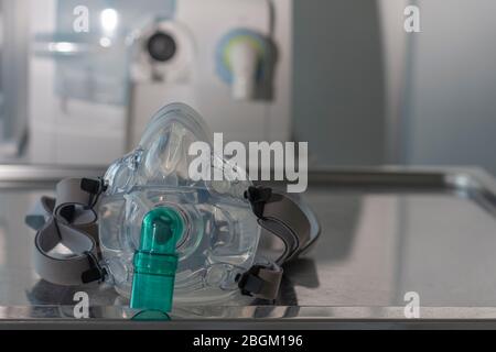 Gesichtsmaske für nichtinvasive ventlationäre Beatmung, auf Hintergrund medizinisches Beatmungsgerät auf der Intensivstation und im Krankenhaus. Stockfoto