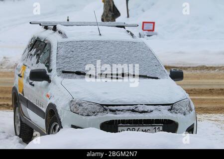 Auto auf einer Straße in der Stadt im Winter mit Schnee bedeckt. Stockfoto