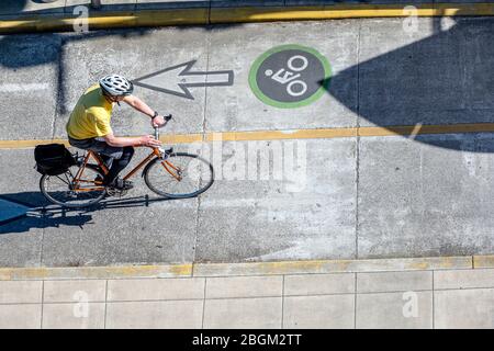 Ein Mann auf dem Fahrrad Pedale ein Fahrrad auf einem dedizierten Weg für Radfahrer bevorzugen einen aktiven gesunden Lebensstil mit Radfahren und Radfahren als alternativ Stockfoto