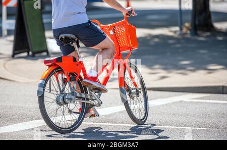 Ein Mann auf einem Fahrrad Pedale ein Fahrrad überquert Straßenbahnschienen auf einer dedizierten Kreuzung für Radfahrer und Fußgänger bevorzugen gesunde Lebensweise mit Radfahren r Stockfoto