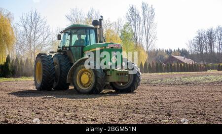 Nagybajcs Hungary 04 04 2020: Ein großer, moderner John Deere 4755 Traktor mit Doppelrädern geht ins Feld. Stockfoto