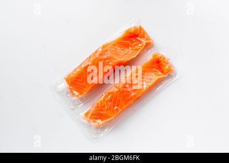 Roter Fisch oder Lachsfilets in Vakuumverpackung auf weißem Hintergrund. Frischer Fisch, Omega 3. Konzept der gesunden Ernährung. Stockfoto