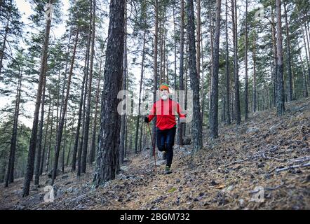 Bärtiger Mann im roten Hemd, nahe beim See und der Herbst. Trail Running Konzept Stockfoto