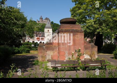 Denkmal für die Opfer von Krieg und Tyrannei in den Rheinanlagen, dahinter Bacharach mit Burg Stahleck Jugendherberge, Bacharach am Rhein, Rheinland Stockfoto